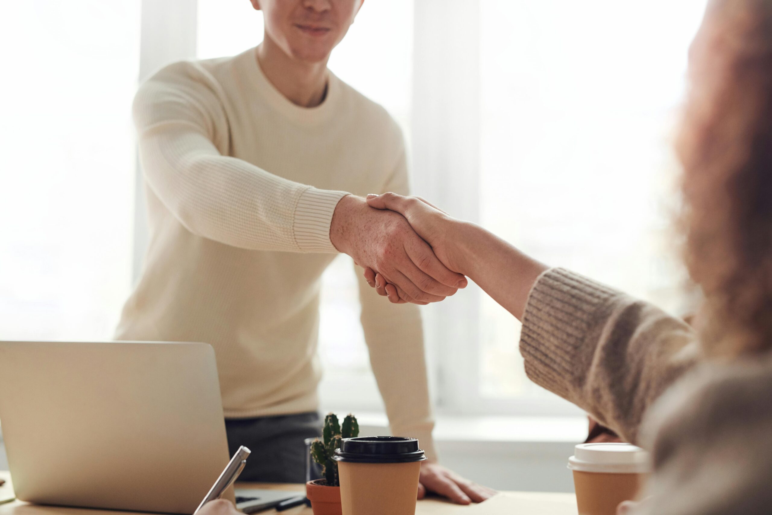 pexels-fauxels-3184465 (37) two people shaking hands over a desk