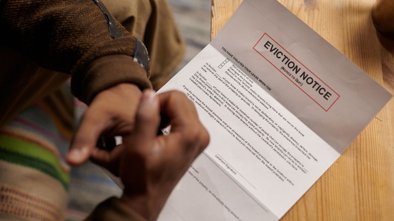 Person reading eviction notice document labeled “Notice to Quit”