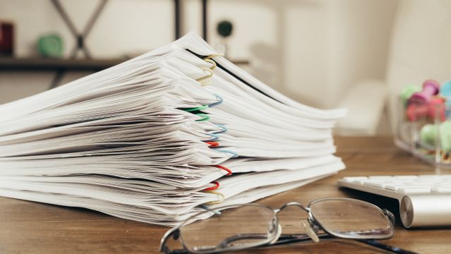 a stack of documents with paperclips